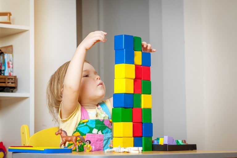 a little girl playing blocks