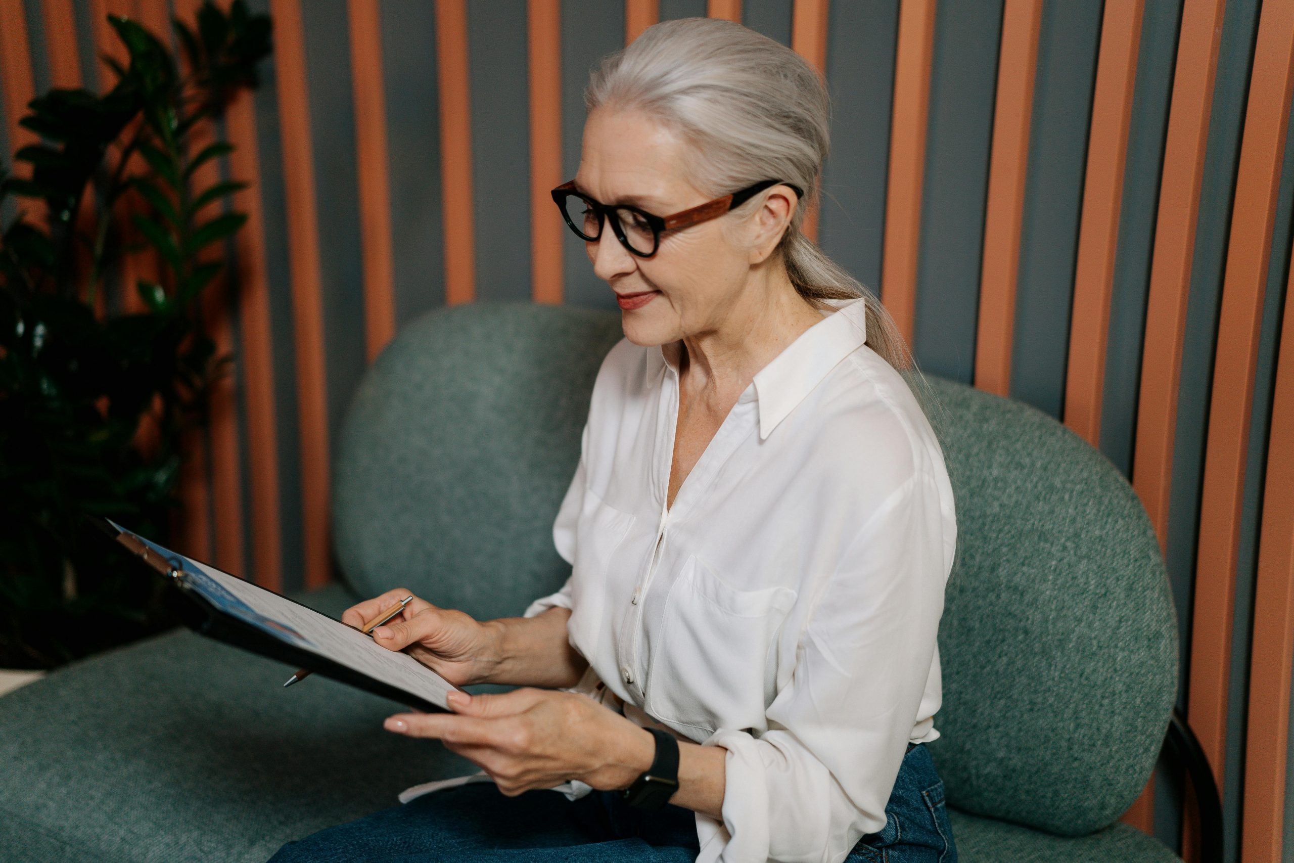 hiring manager wearing glasses, smiling while reading a candidate's resume