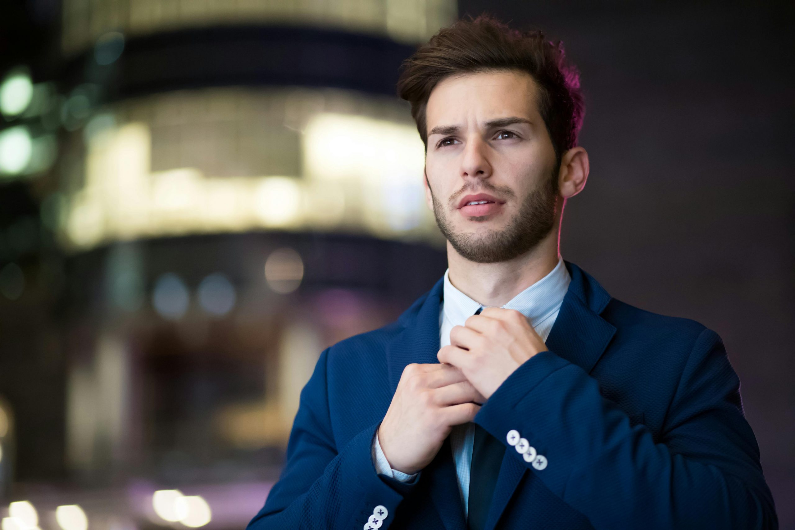 confident man in a suit adjusting his necktie