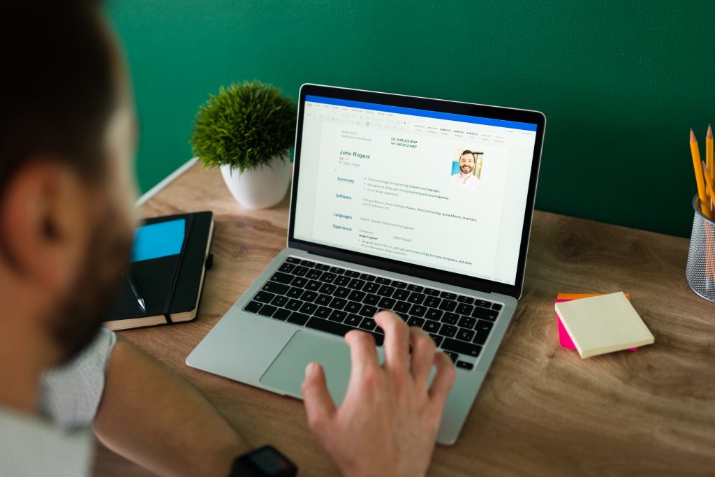 man working on his resume using a laptop